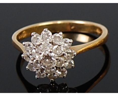 An 18ct gold diamond flower head cluster ring, as a three-tiered setting of graduated brilliants, the centre stone weighing a