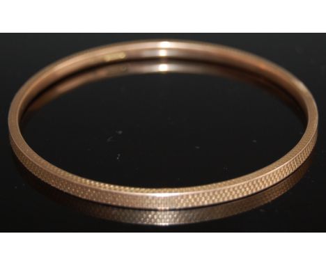A 9ct gold bangle having engine turned decoration, 25.1g, dia. 7.4cm