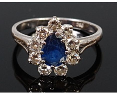 An 18ct white gold, sapphire and diamond cluster ring, the centre pear cut sapphire weighing approx 0.85ct, in a surround of 