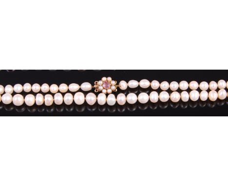 A cultured and knotted pearl single string necklace, having vintage 9ct gold, amethyst and seed pearl set clasp, 60cm