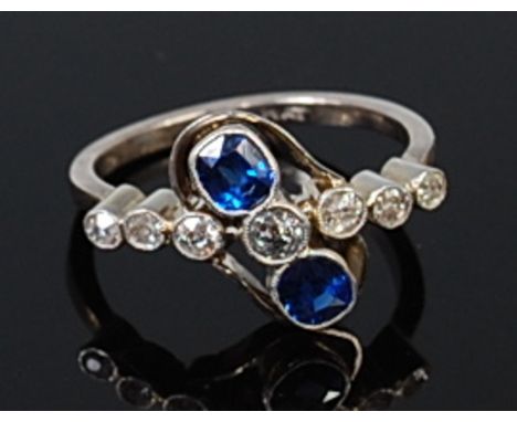 An Art Deco 18ct white gold, sapphire and diamond dress ring, arranged as seven illusion set graduated old cut diamonds in a 