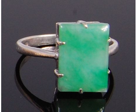 An Art Deco style white metal and jade set dress ring, the cabochon claw set stone in a raised setting, 4g, size Q/R   Condit