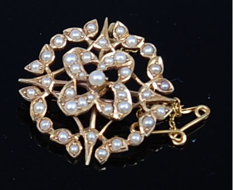 An Edwardian 15ct gold and seed pearl set open work pendant brooch, with safety chain, 6.7g, dia. 2.8cm
