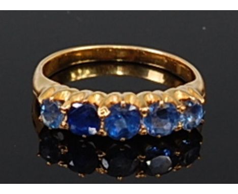 An 18ct gold sapphire five stone ring, the claw set round cut sapphires in a line setting, the centre stone weighing approx 0