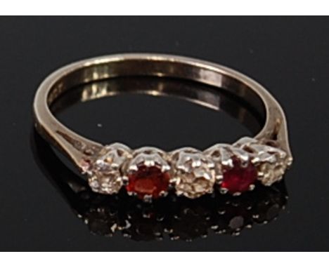 An 18ct white gold, ruby and diamond ring, the three claw set old cut diamonds dispersed by single round cut ruby in a line s