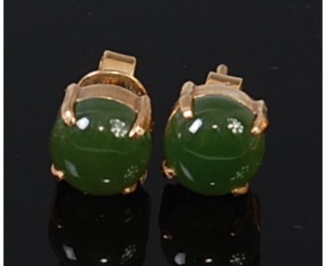 A pair of yellow metal and cabochon green jade set ear studs, dia. 8mm
