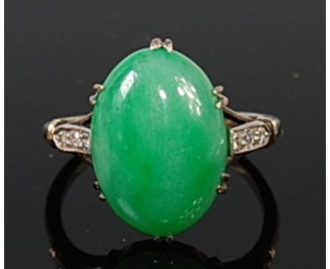 An 18ct white gold and platinum jade set ring, the claw set cabochon jade measuring 15 x 11mm, the shoulders each pavé set wi