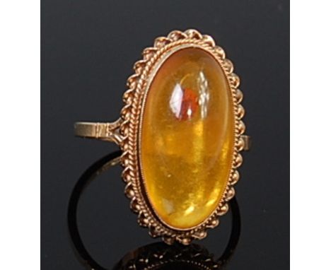 A modern 9ct gold and cabochon clear orange amber set ring, the amber measuring 20 x 10mm, 3.3g, size N/O