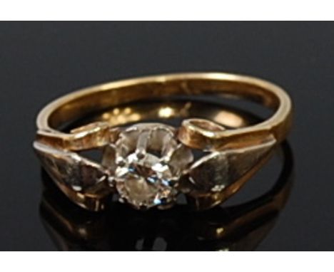 A yellow metal diamond solitaire ring, the claw set brilliant weighing approx. 0.18ct flanked to either side with raised and 