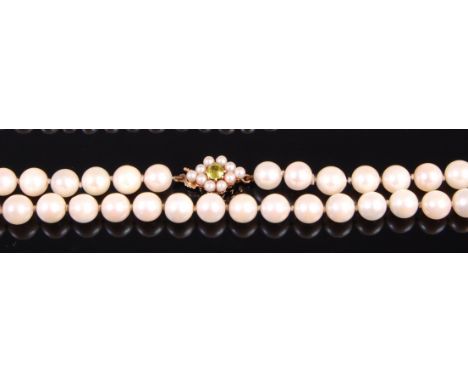 A cultured and knotted pearl single string necklace, having green topaz and seed pearl set 9ct gold clasp, 47cm