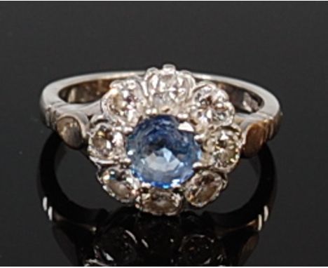 A platinum, pale blue sapphire and diamond flower head cluster ring, the claw set round cut sapphire weighing approx 0.75ct, 