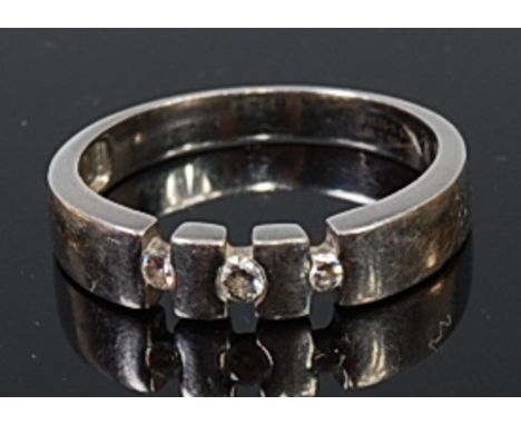 A modern platinum and diamond dress ring, arranged as three graduated brilliants in an open setting, total diamond weight est