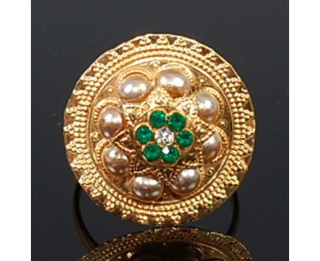 An Indian high carat yellow metal, precious and semi-precious set ring, set with six small round cut emeralds around a centra