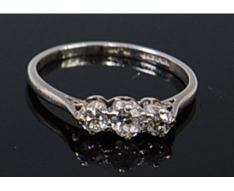 A platinum and diamond three stone ring, the claw set old cut diamonds in a line setting, the largest weighing approx 0.18ct,