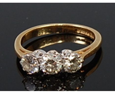 An 18ct gold and diamond three stone ring, the three claw set brilliants in a line setting, each weighing approx 0.25ct, size