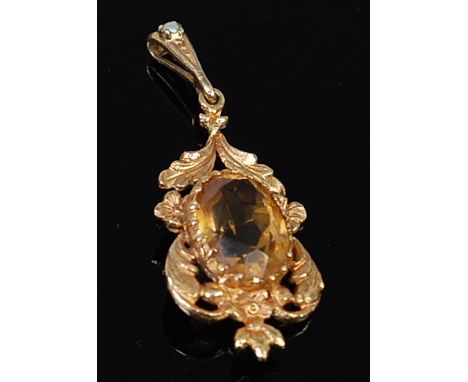 A 9ct gold and citrine set pendant, the large oval cut citrine in a leaf chased setting, the bale set with a single cultured 