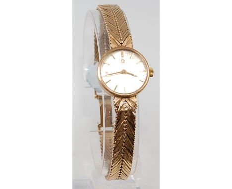 An Omega ladies 9ct gold bracelet watch, having signed champagne dial with baton markers, manual wind movement, and original 