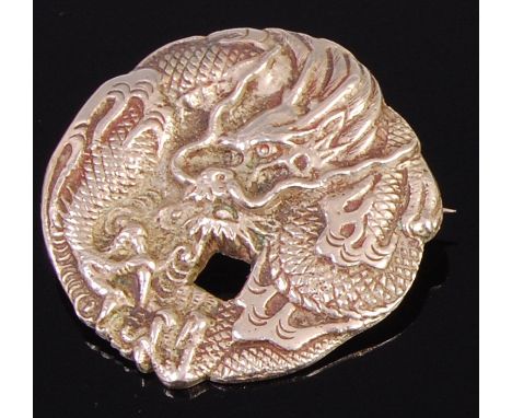 A Japanese Meiji period silver brooch, possibly converted from a button, chased in relief with serpent, later marked verso Na