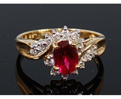 An 18ct gold, ruby and diamond dress ring, the four claw set oval cut ruby weighing approx 0.8ct, in a surround of small bril