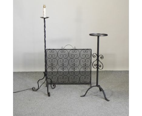 A black wrought iron fire screen, 74cm, together with two candle stands
