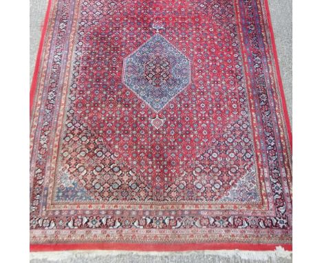 A Hamadan carpet, on a red ground, 346 x 251cm