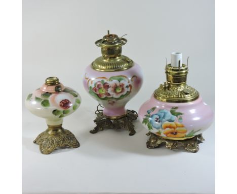 An opaline oil lamp, decorated with flowers, together with two others, highest 33cm