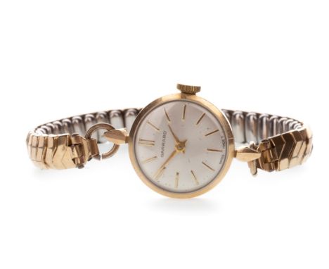 LADY'S GARRARD NINE CARAT GOLD MANUAL WIND WRIST WATCH, the round dial with applied gold baton hour markers, gold sword hands
