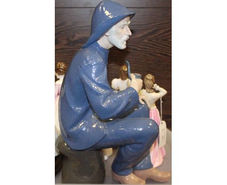 GOOD LARGE NAO FIGURE
modelled as a fisherman seated on a bollard; together with four modern Royal Doulton ladies: 'Gift of l