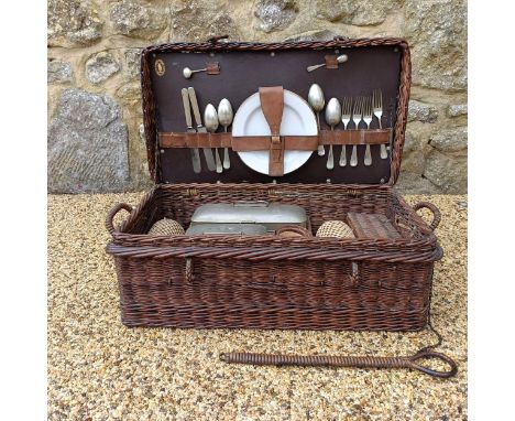 An early 20th century picnic set, with rattan covered items, in a wicker hamper, 68 cm widea couple of old worm holes