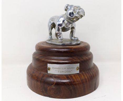A Desmo bulldog chrome mascot, mounted on a turned wood base, applied a plaque Banister Ward, Top Dog, 14 cm high