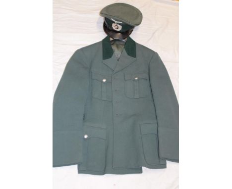 A copy German Army Officers peaked cap with alloy insignia together with accompanying green four-pocket tunic 
