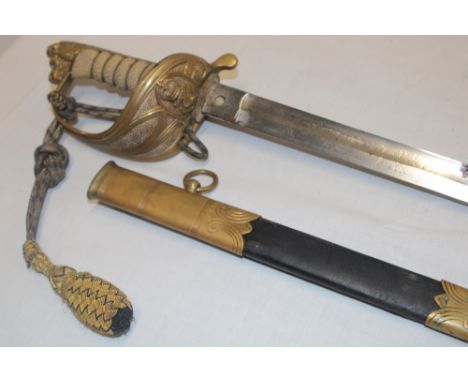 A post 1902 Royal Naval Officer's sword with etched steel blade, brass guard with King's crown anchor emblem, wire bound fish