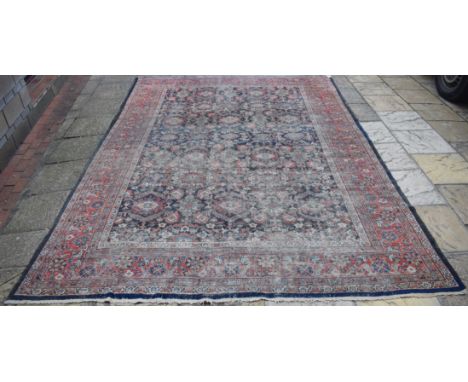 A Persian carpet, decorated floral motifs on a dark blue ground, within a multi border, 356 x 257 cm Condition report Report 