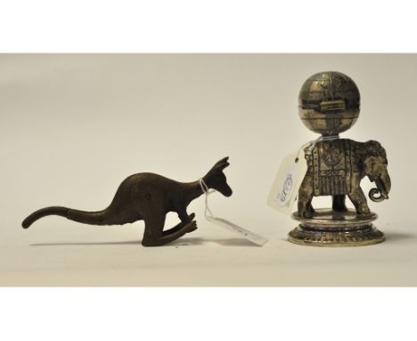 A plated inkwell, in the form of an elephant, 12.5 cm high, and a carved iron kangaroo toy (2)