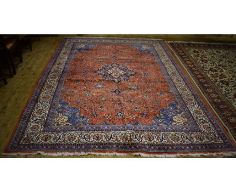 A Persian Sariugh carpet, decorated a central medallion and floral and foliate motifs on an orange ground, within a multi bor
