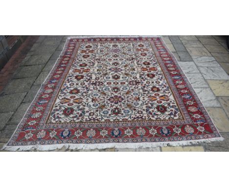 A Persian carpet, decorated floral motifs on a white ground, within a multi border, 324 x 237 cm