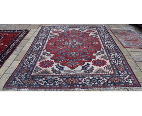 A Persian Tabriz carpet, decorated birds and foliage on a red ground, within a multi border, 332 x 241 cm