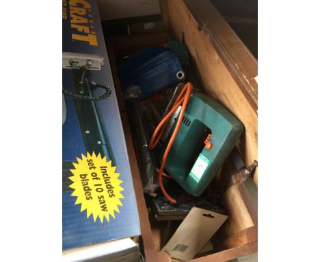 A wooden box containing tools and power tools 