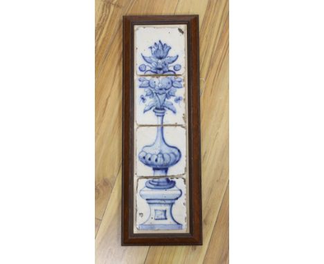 A 17th century Delft four tile framed panel, painted in underglaze blue with a vase of flowers on a pedestal, 64 cms high,