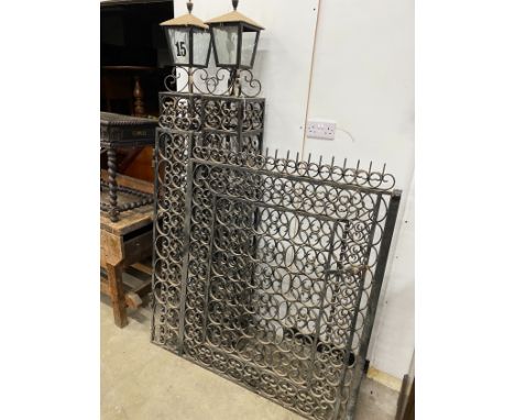 A pair of black painted wrought iron scroll work gates with matching lantern posts, total width 286cm, post height 196cm