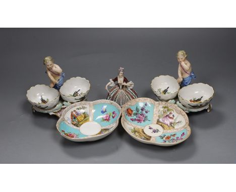 Two Berlin figural salts, 13cm high together with two Dresden saucers and a continental figurine