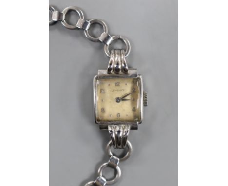 A lady's stainless steel Longines manual wind wrist watch, with fluted lugs, on associated steel chain link bracelet.