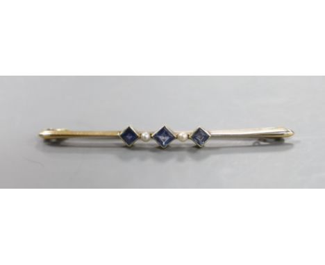 An Edwardian 15ct, three stone sapphire and two stone seed pearl set bar brooch, 57mm, gross 3.4 grams.