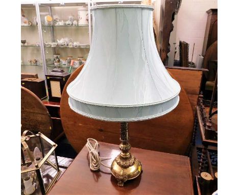 A decorative brass table lamp with shade