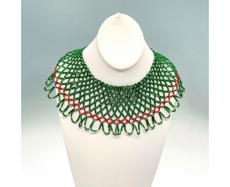 The necklace is made up of small iridescent glass bugle beads in red, green, and clear with a looped beaded border. Dimension