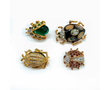 Four gold tone brooch pins with various materials including enamel, mother of pearl, and crystal. 1st pin: 1"L x 1"W. 2nd pin