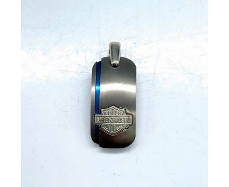 Arched oblong shape with Harley Davidson logo and vertical blue stripe on the left side. 1"L x 0.5"W. Dimensions: 1"L x 0.5"W