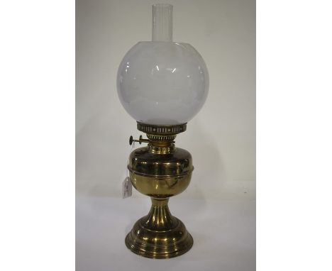 Duplex oil lamp, with frosted white globe and clear glass chimney above a brass reservoir, waisted stem and domed foot, 50.5c