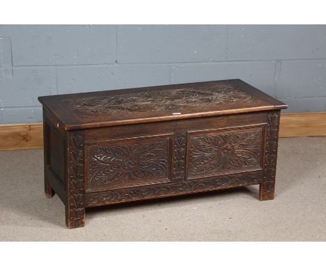 18th century style carved oak coffer, the hinged lid with carved foliate swags and similar front panel, 105cm wide x 47cm dee