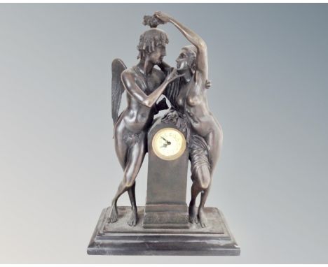 An Art Nouveau style patinated metal mantel clock on black marble base. (height 42cm)